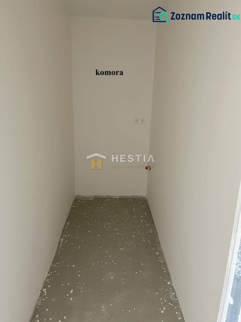 Ein kleiner Abstellraum in einer 2-Zimmer-Wohnung mit weißen Wänden und Betonboden.