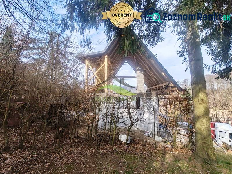 Der Bau der Hütte auf dem Zajačia debra in Holčíkovce, umgeben von Wald und Grün.