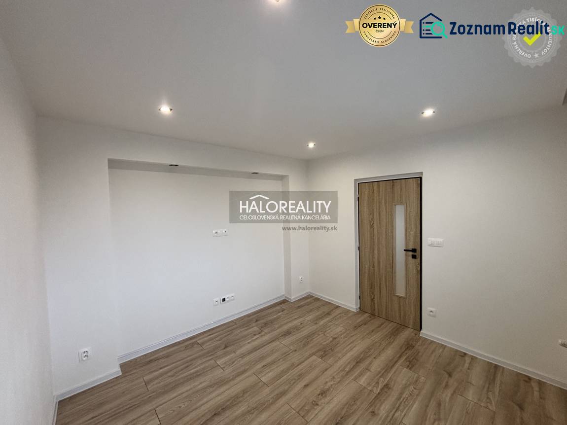 Ein geräumiger Raum mit Holzboden und eingelassener Beleuchtung in einer 3-Zimmer-Wohnung.