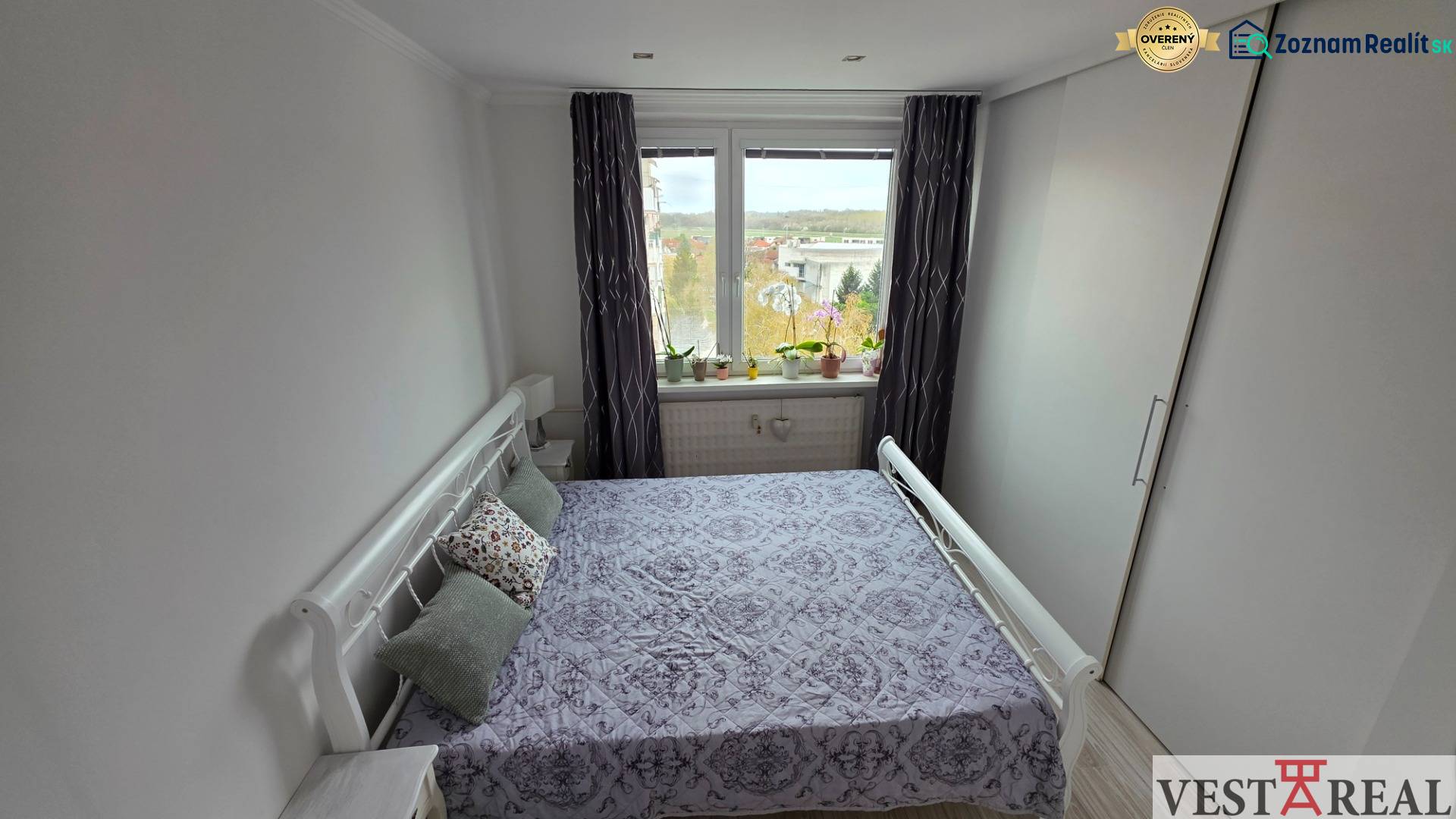 Schlafzimmer in einer 3-Zimmer-Wohnung mit großem Fenster und Einbauschrank.