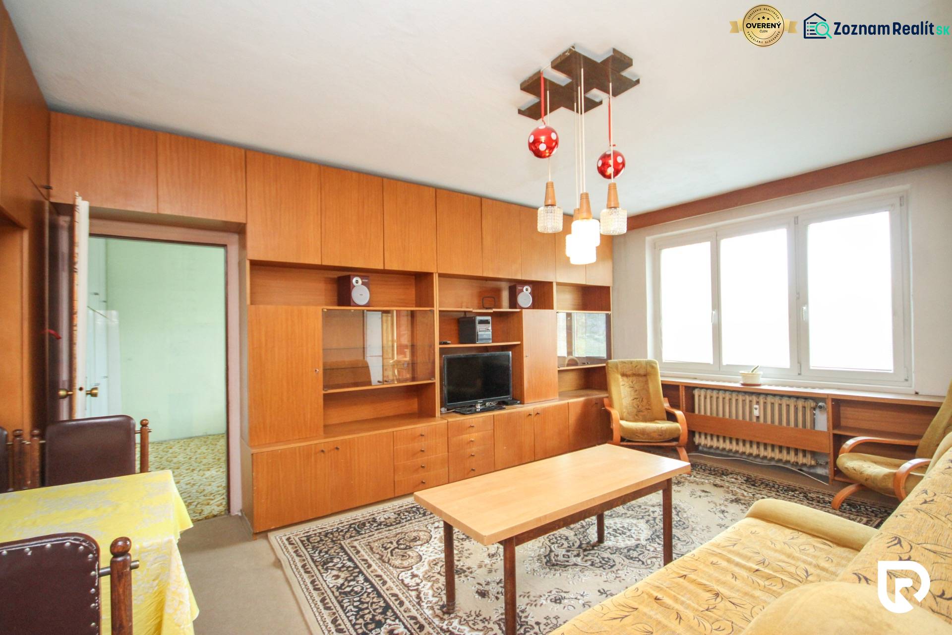Ein Zimmer in einer 2-Zimmer-Wohnung mit Holzvertäfelung und Retro-Möbeln.