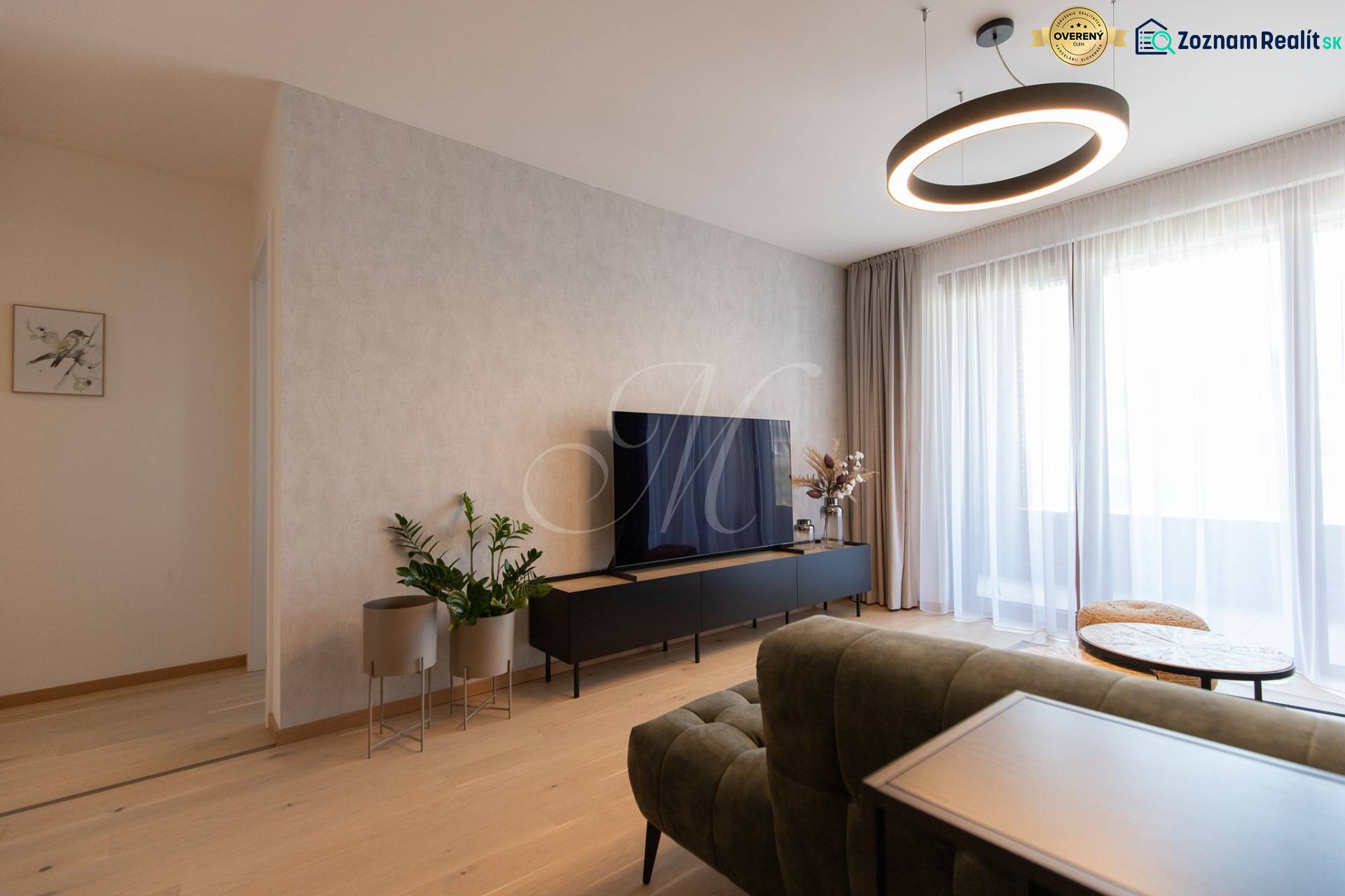 Wohnbereich in einer 2-Zimmer-Wohnung mit Holzboden und Fernseher.