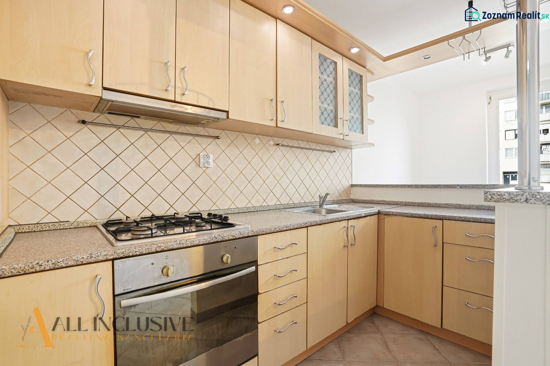 Küche in einer 2-Zimmer-Wohnung mit einem Gasherd und hellen Küchenschränken.