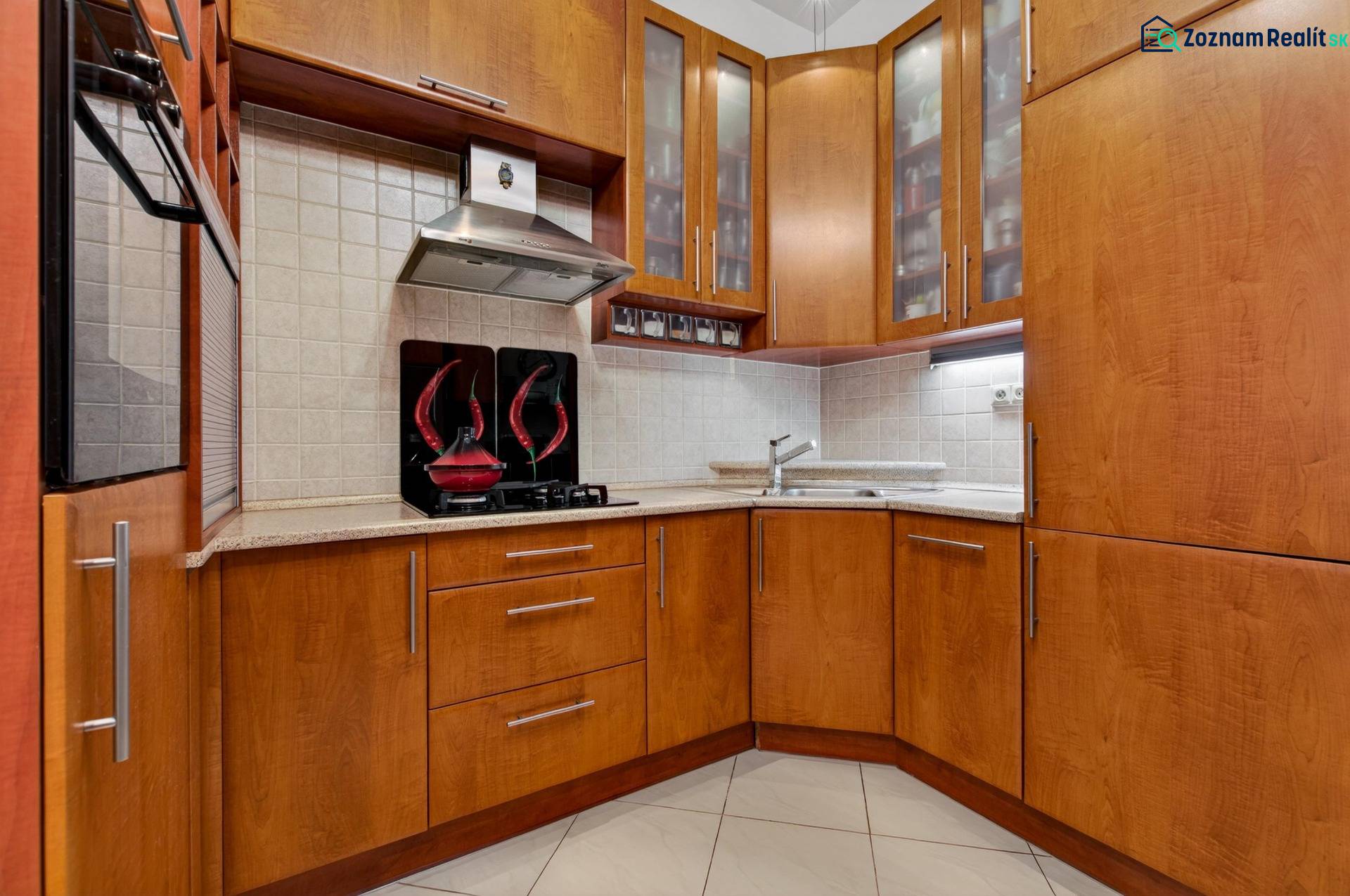 Küche in einer 3-Zimmer-Wohnung mit Holzmöbeln und eingebauten Geräten.