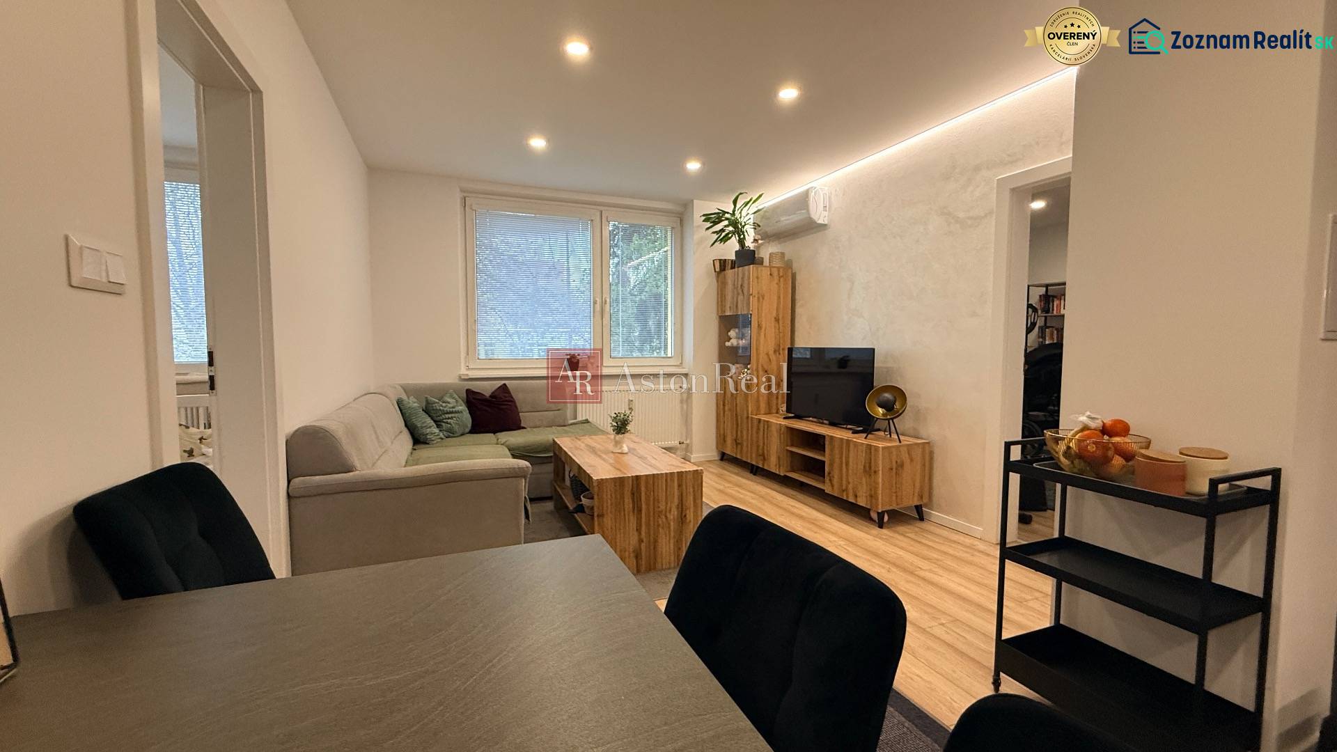 Wohnzimmer mit Sofa, Fernseher und Dekoration auf dem Boden in einer 4-Zimmer-Wohnung.