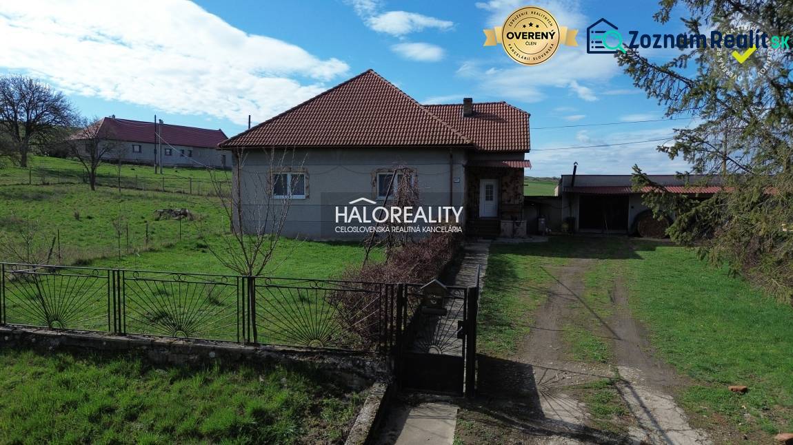 Ein Einfamilienhaus in Rimavské Janovce auf einem Grundstück mit grünem Rasen und Umzäunung.