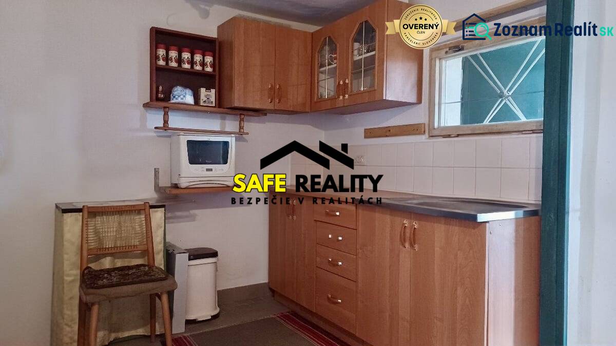 Eine Küche in einer Hütte mit Holzmöbeln und einer Mikrowelle, Boden mit Holzdekor.