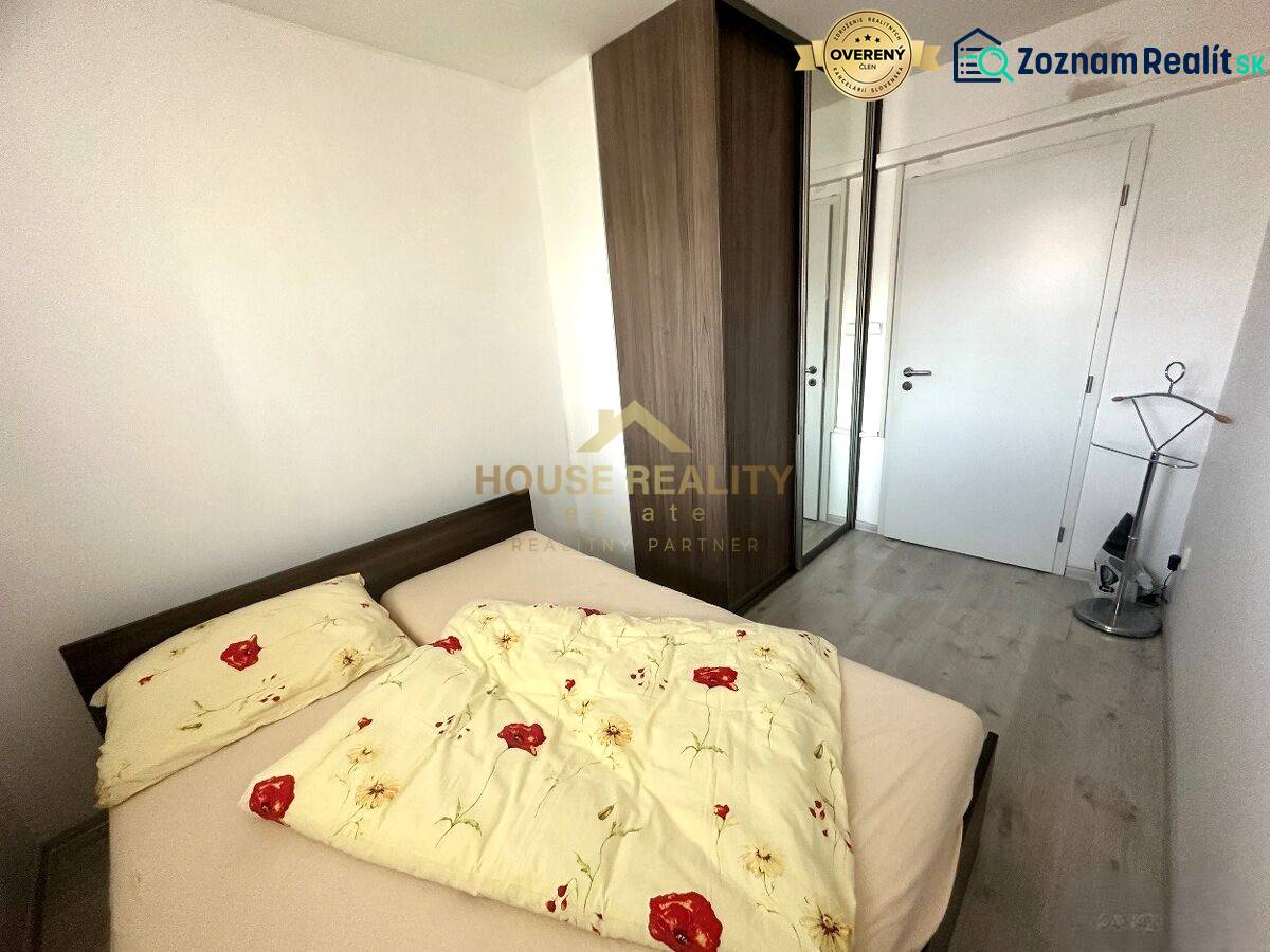 Schlafzimmer in einer 2-Zimmer-Wohnung mit Bett, Einbauschrank und Bodenbelag in Holzoptik.