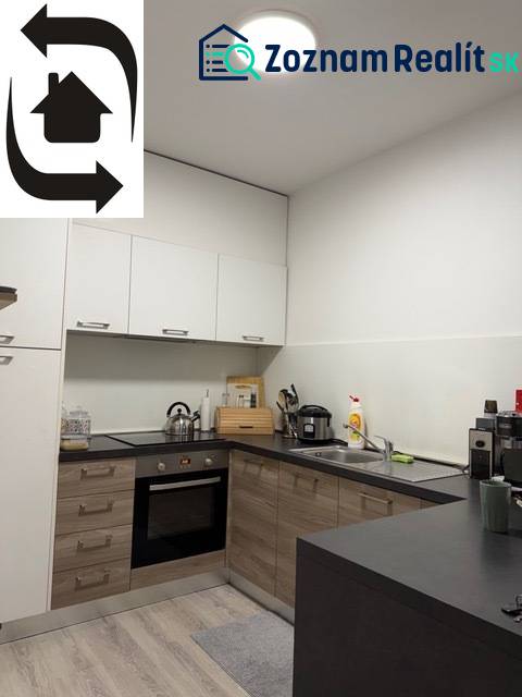 Küche in einer 2-Zimmer-Wohnung mit Holzboden und weißen Schränken.