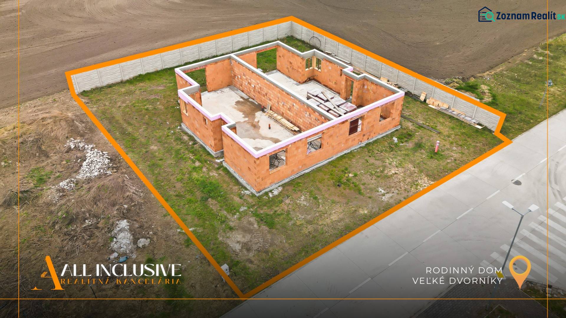 Der Bau eines Einfamilienhauses in Veľké Dvorníky auf einem von einem Zaun umgebenen Grundstück.