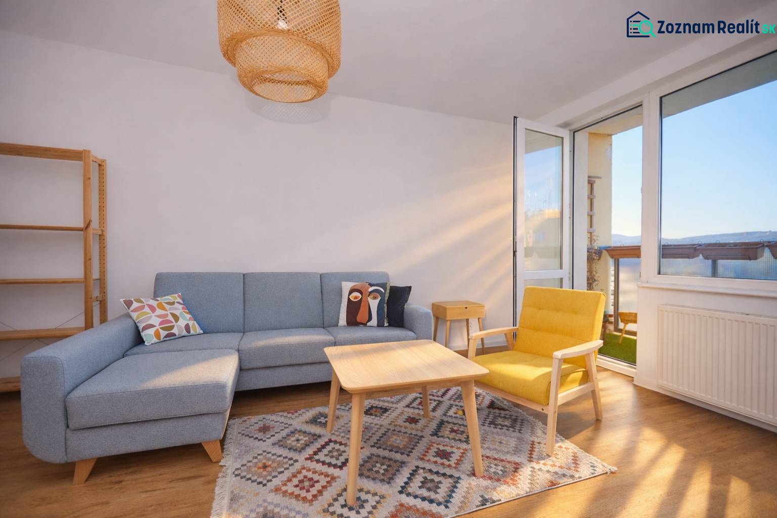 Wohnzimmer mit Sofa, gelbem Sessel, Teppich und Boden mit Holzdekor in einer 3-Zimmer-Wohnung.