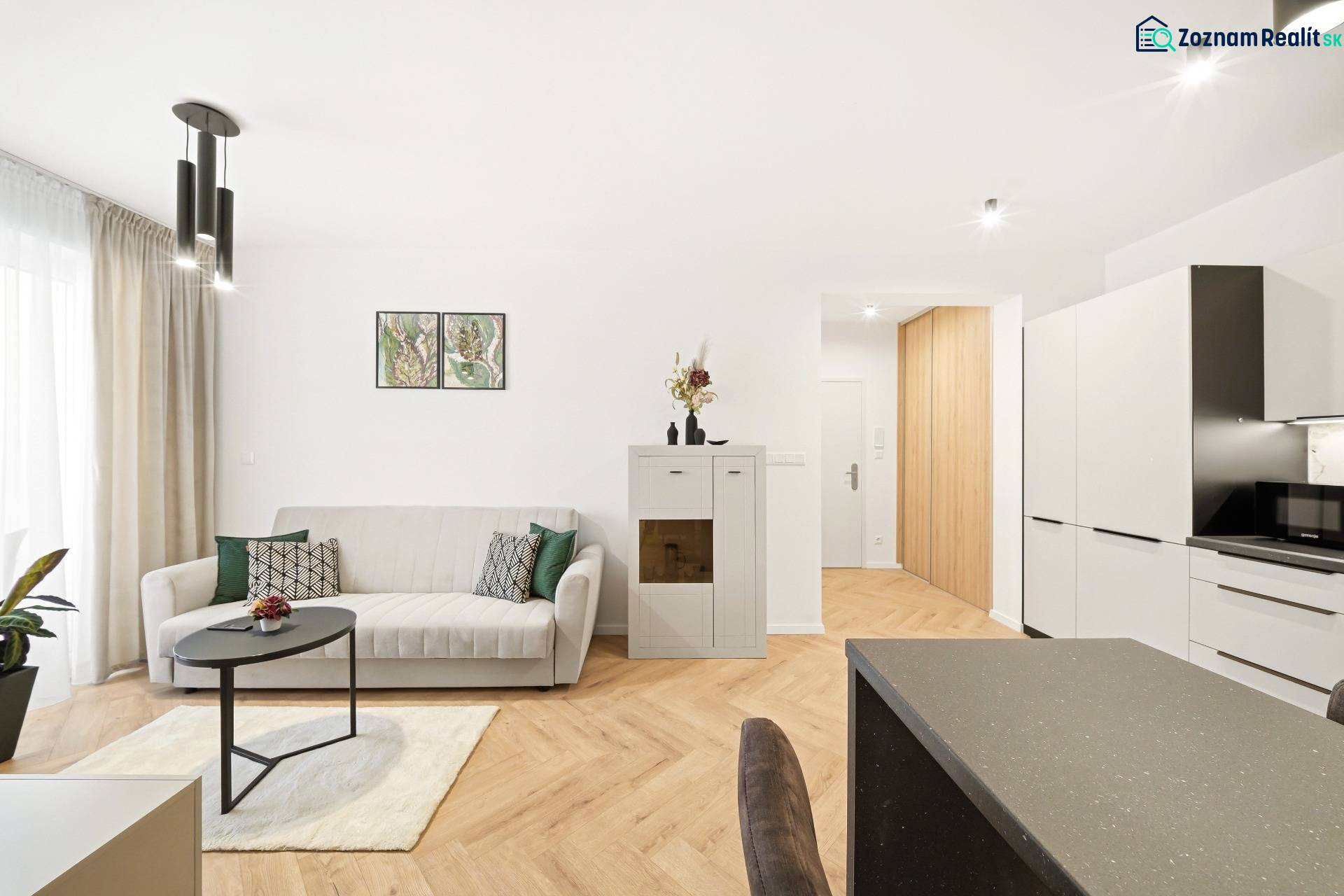 Wohnzimmer in einer 4-Zimmer-Wohnung mit einem weißen Sofa und einem Boden in Holzoptik.