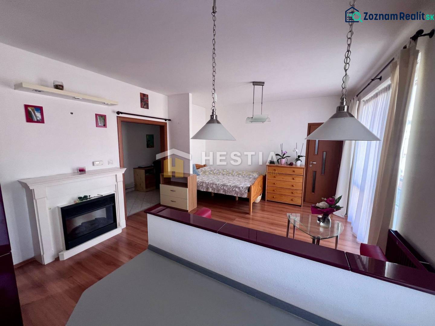 1-Zimmer-Wohnung mit Kamin, Hängeleuchten und Holzmöbeln, ideal zur Vermietung.
