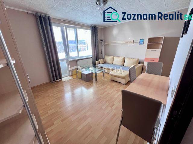 Wohnzimmer einer Zweizimmerwohnung mit Holzboden und hellen Möbeln.