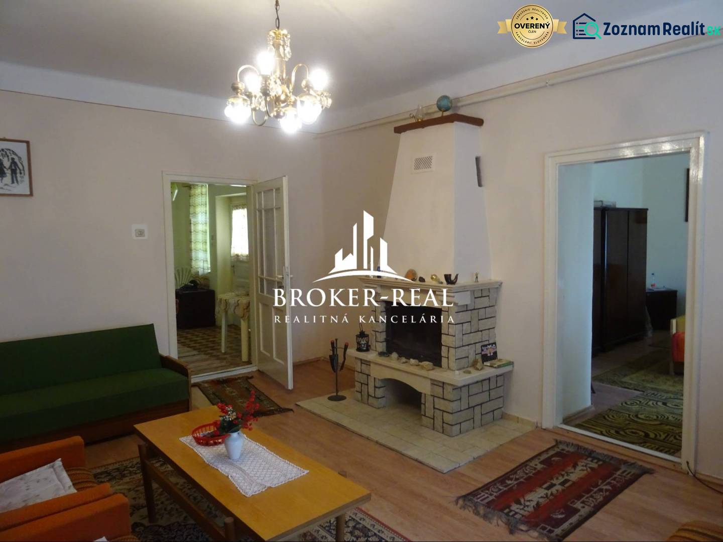 Wohnzimmer in einem Einfamilienhaus mit Kamin, Holzboden und Kronleuchter.