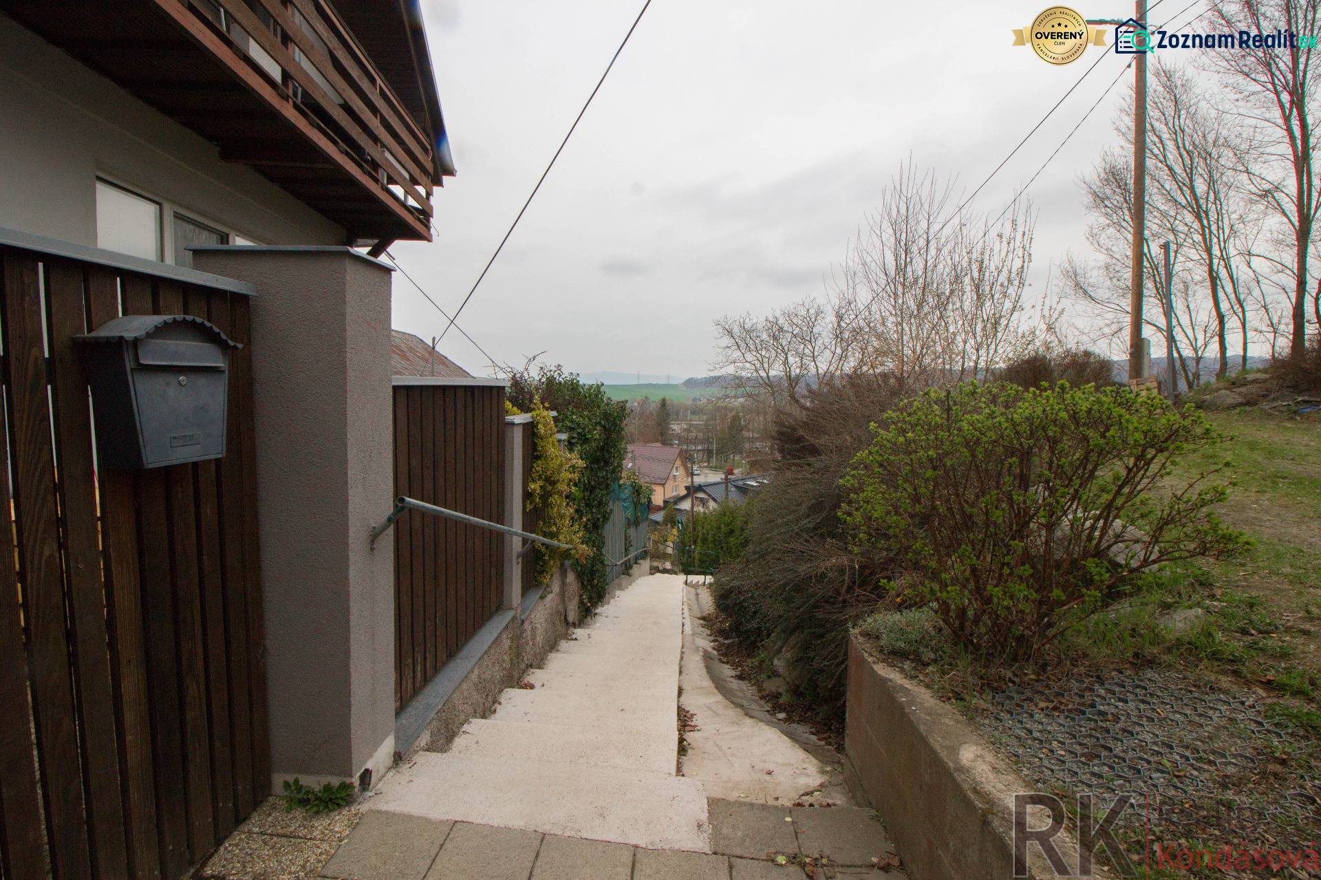 Zugangspfad zu einem Einfamilienhaus in Kostoľany nad Hornádom, umgeben von einem Holzzaun.