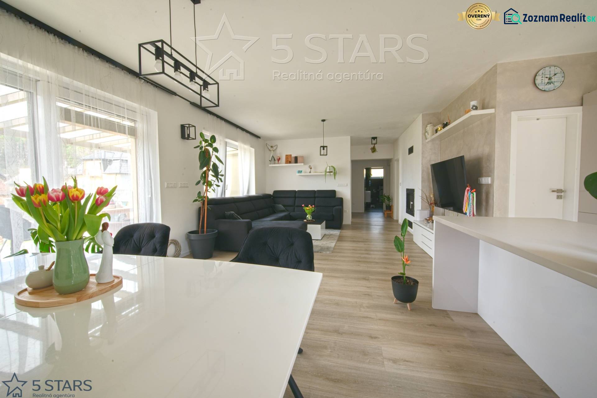 Innenraum eines Einfamilienhauses mit Holzboden, Esstisch und Sofa.