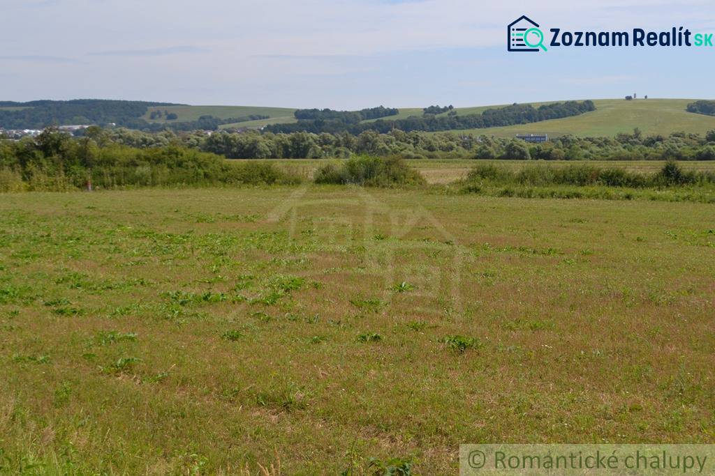Landwirtschaftliche und forstwirtschaftliche Grundstücke in Šandali mit einer weitläufigen Wiese und entfernten Wäldern.