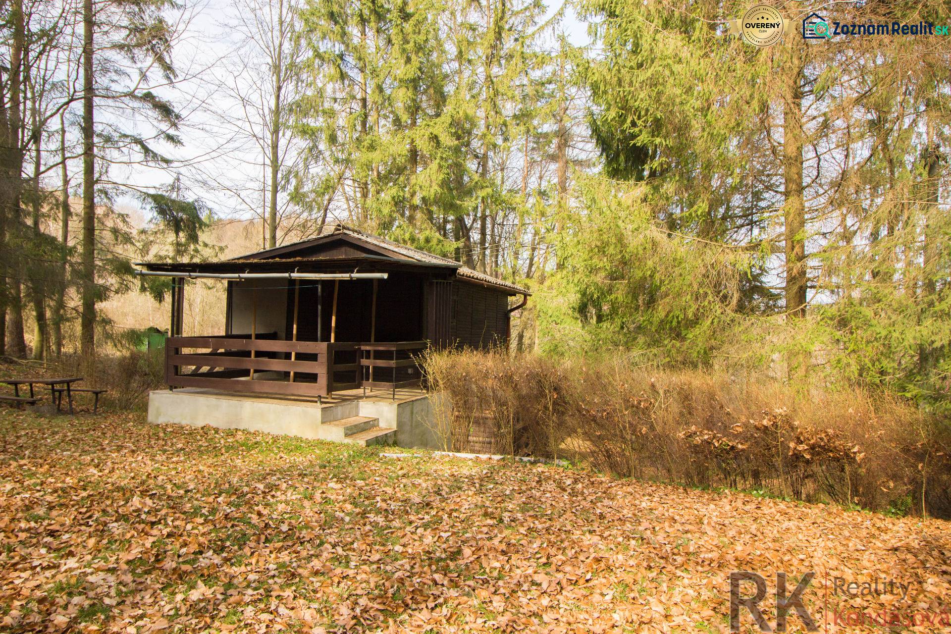 Eine Hütte umgeben von Wald auf Erholungsgrundstücken in Holčíkovce im Herbst.