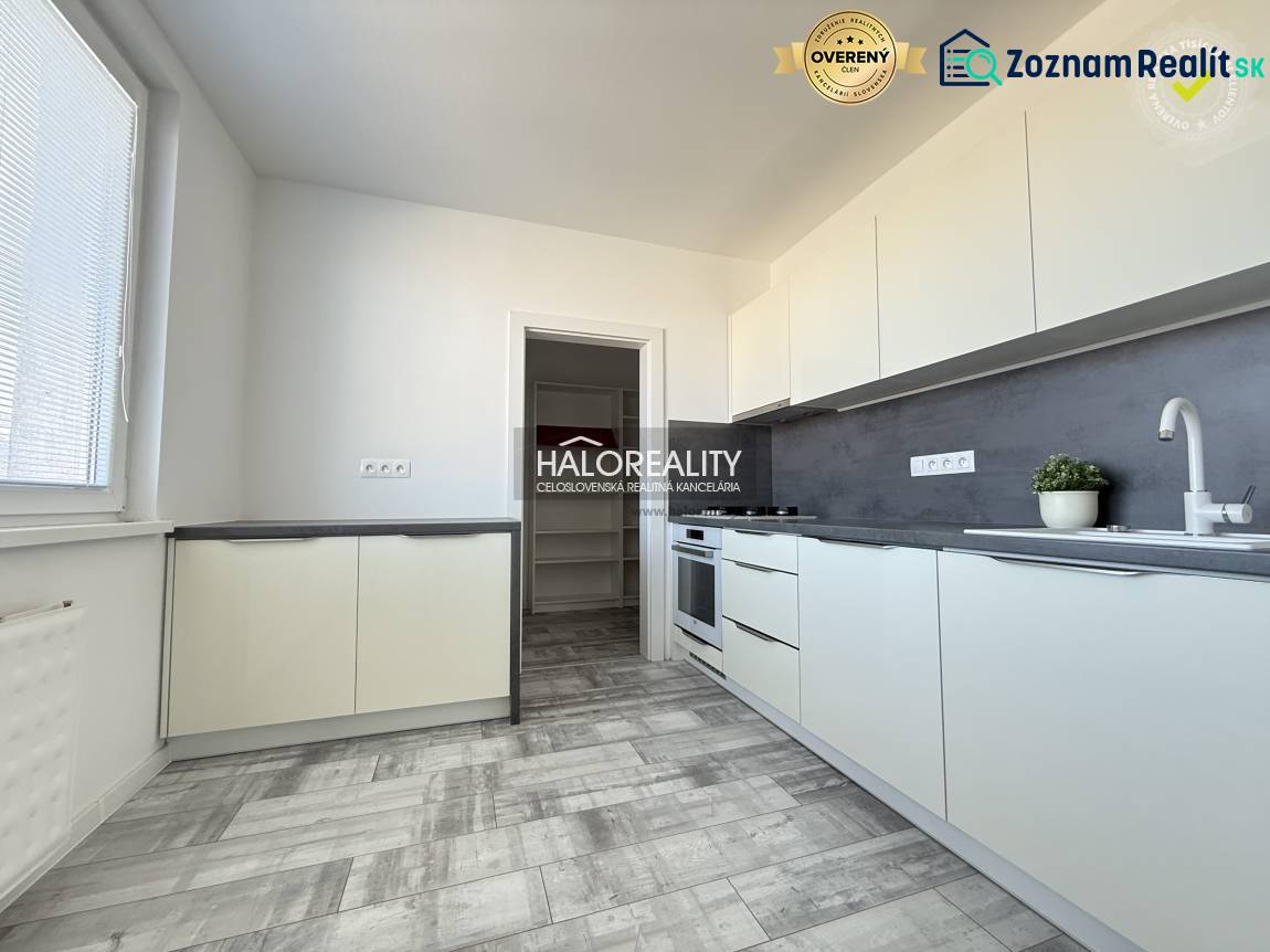 Küche in einer 2-Zimmer-Wohnung mit Holzboden und hellen Möbeln.