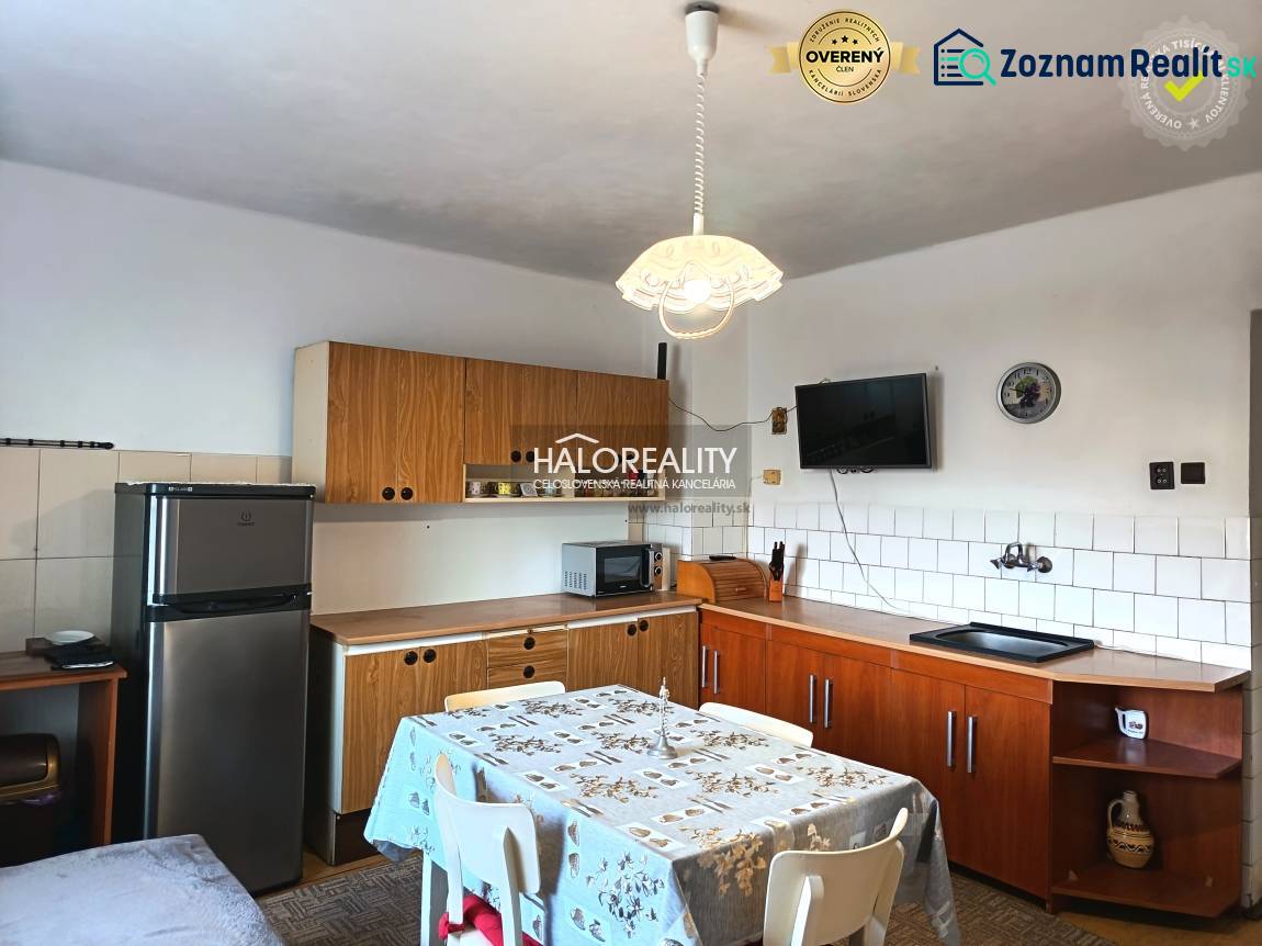 Eine Küche in einem Einfamilienhaus mit Holzkücheneinrichtung und Esstisch.