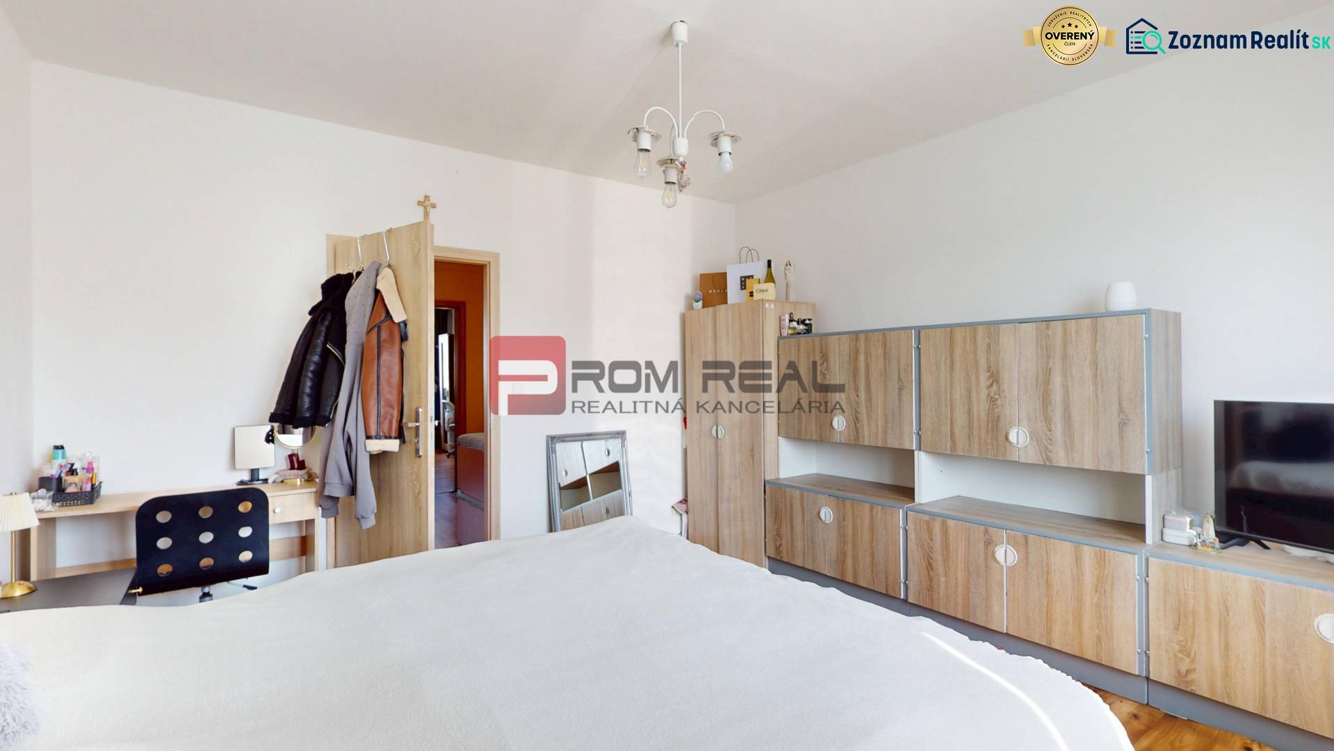 Schlafzimmer mit Einbaumöbeln und Schreibtisch in einer Vierzimmerwohnung.