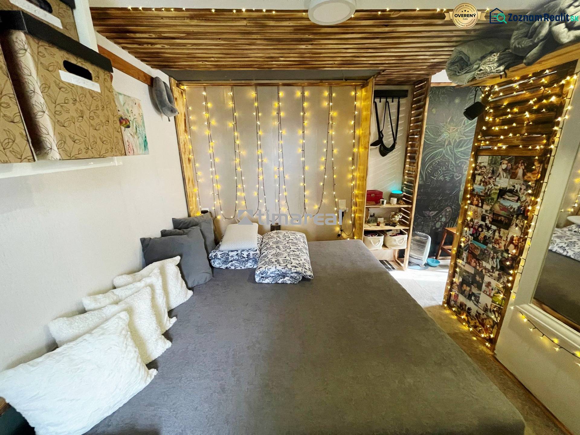 Interieur eines Einfamilienhauses mit Bett, Kissen und Lichtdekoration.