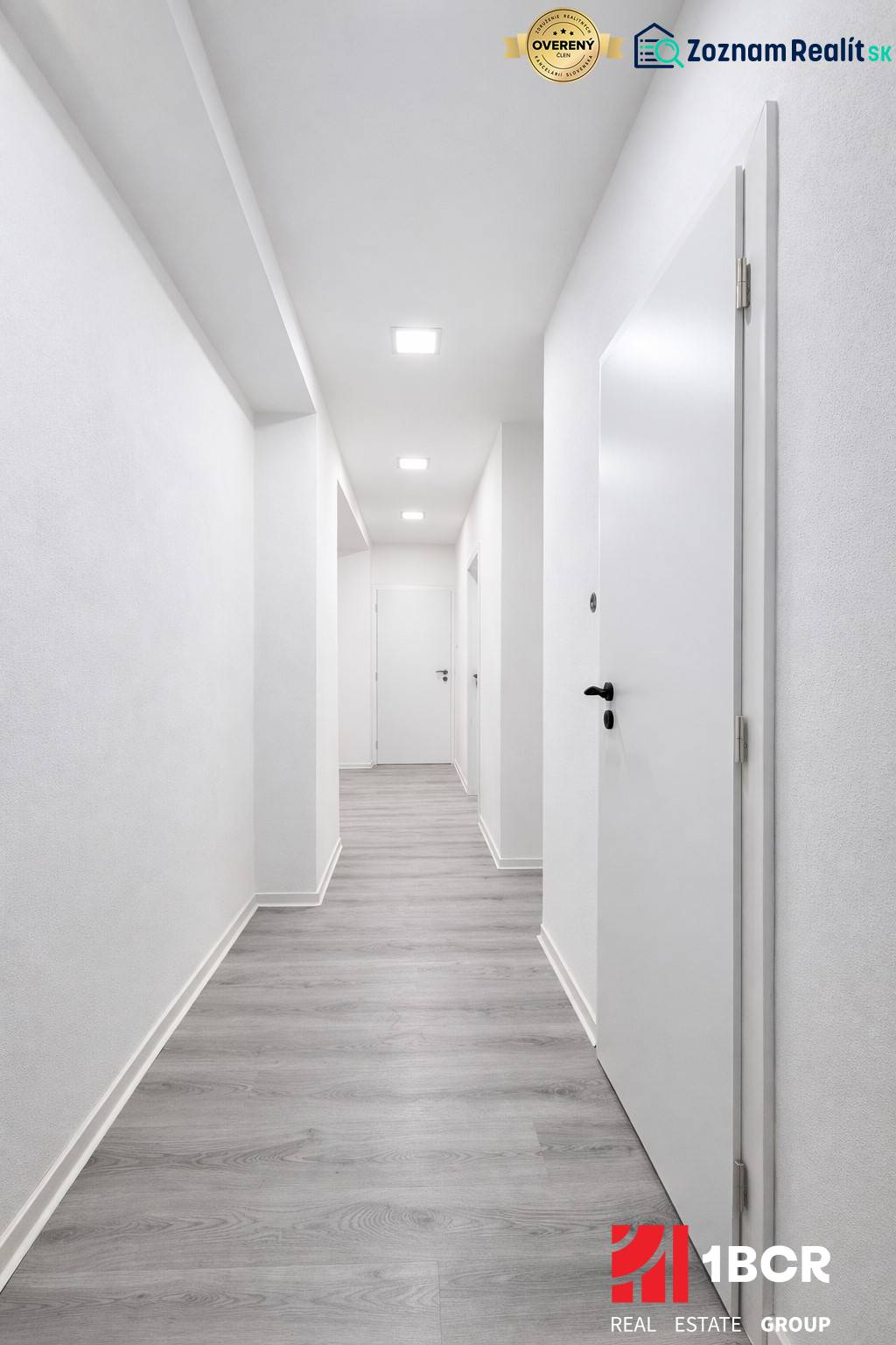 Ein Flur mit weißen Wänden und einem Boden in Holzoptik in einer 3-Zimmer-Wohnung.