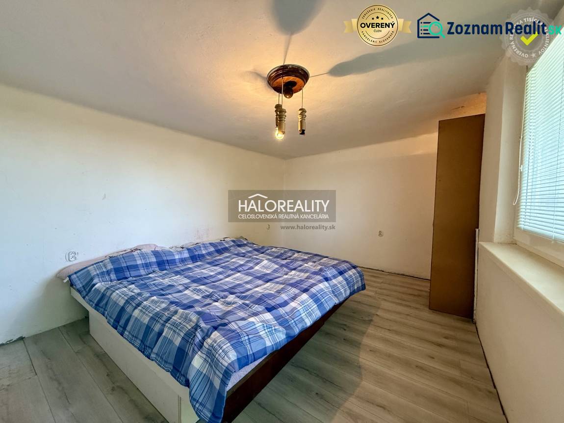 Ein ruhiges Schlafzimmer mit einem einfachen Bett und einem Boden in Holzoptik.