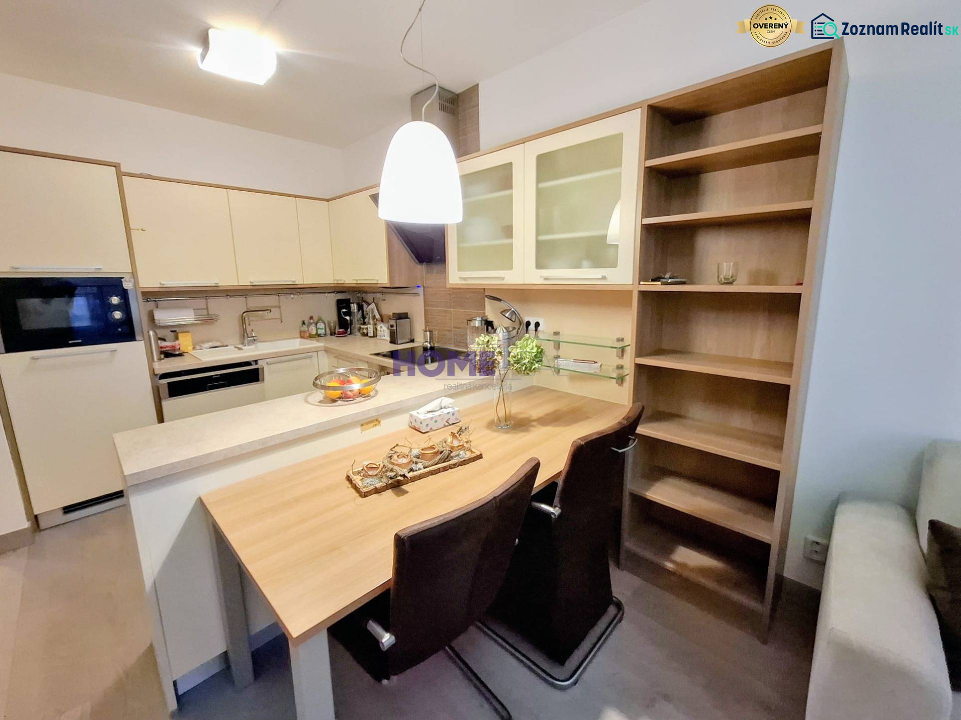 Küchenbereich in einer 2-Zimmer-Wohnung mit Bartresen und Einbauschränken.