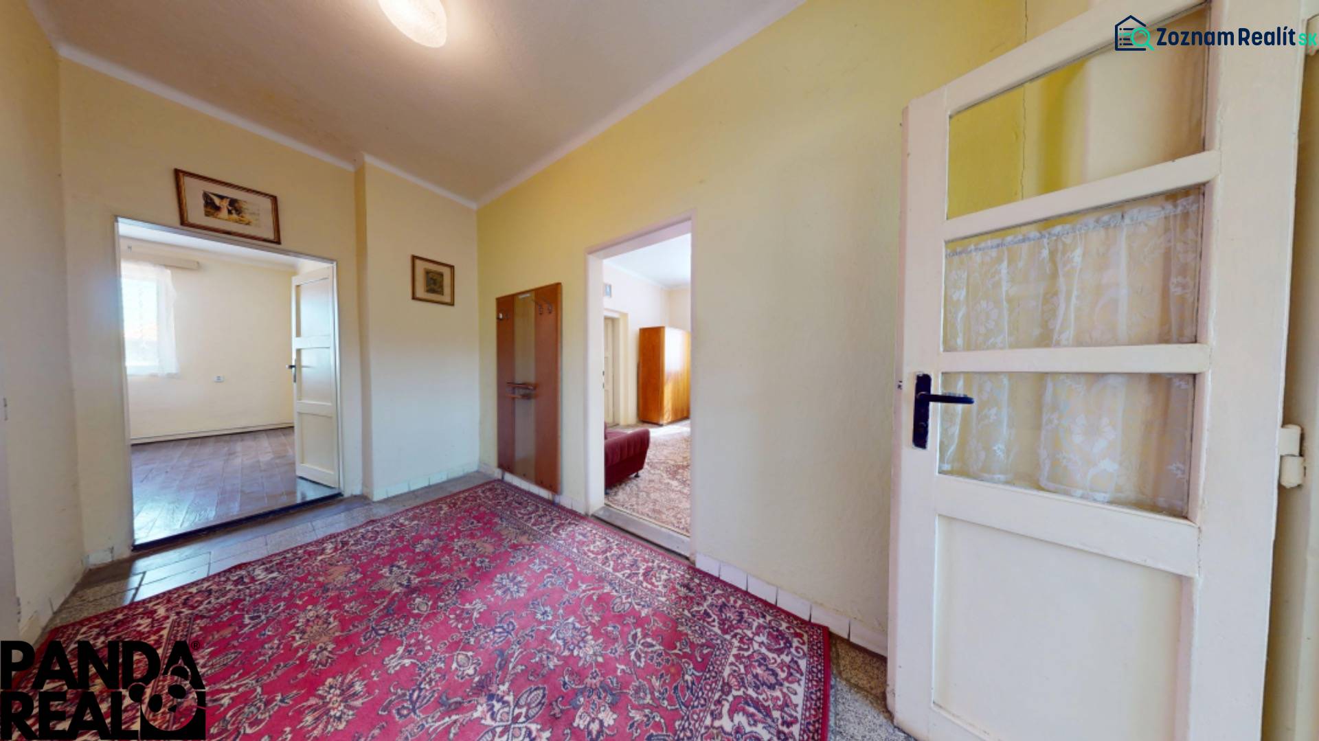 Der Flur eines Einfamilienhauses mit Teppichboden und hellen Räumen.