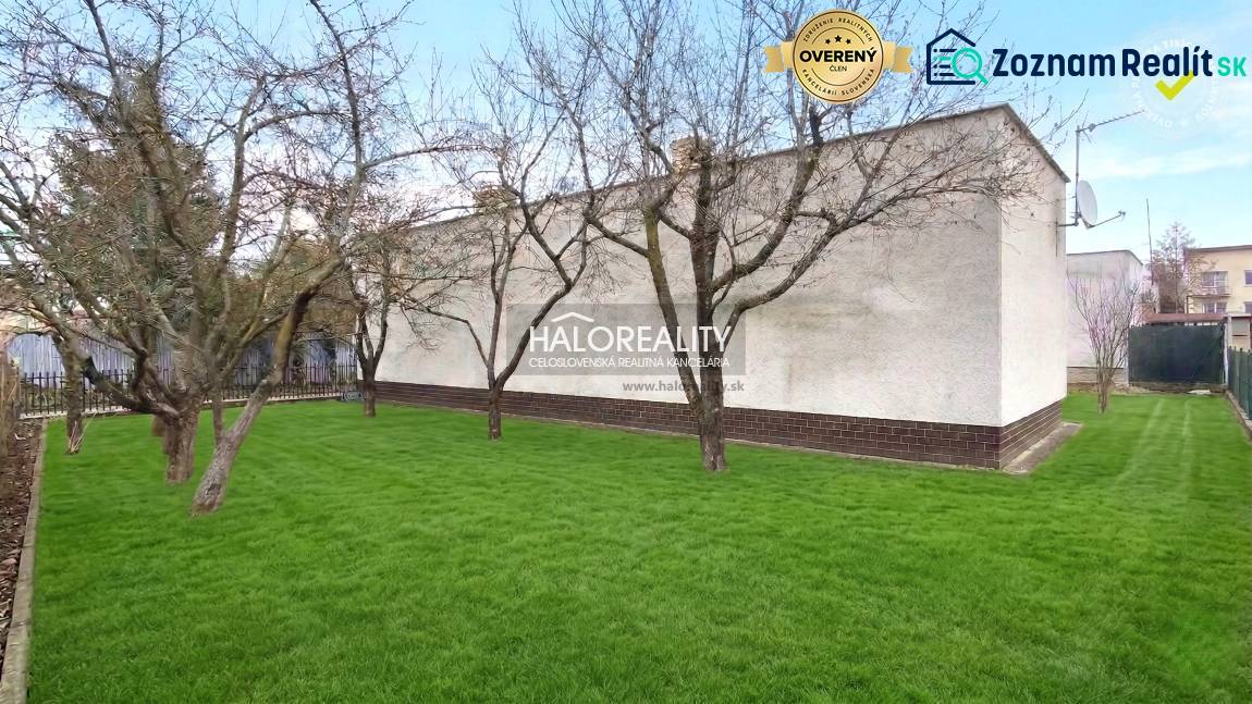 Ein Garten mit Rasen und Bäumen bei einem Einfamilienhaus in Poltár.