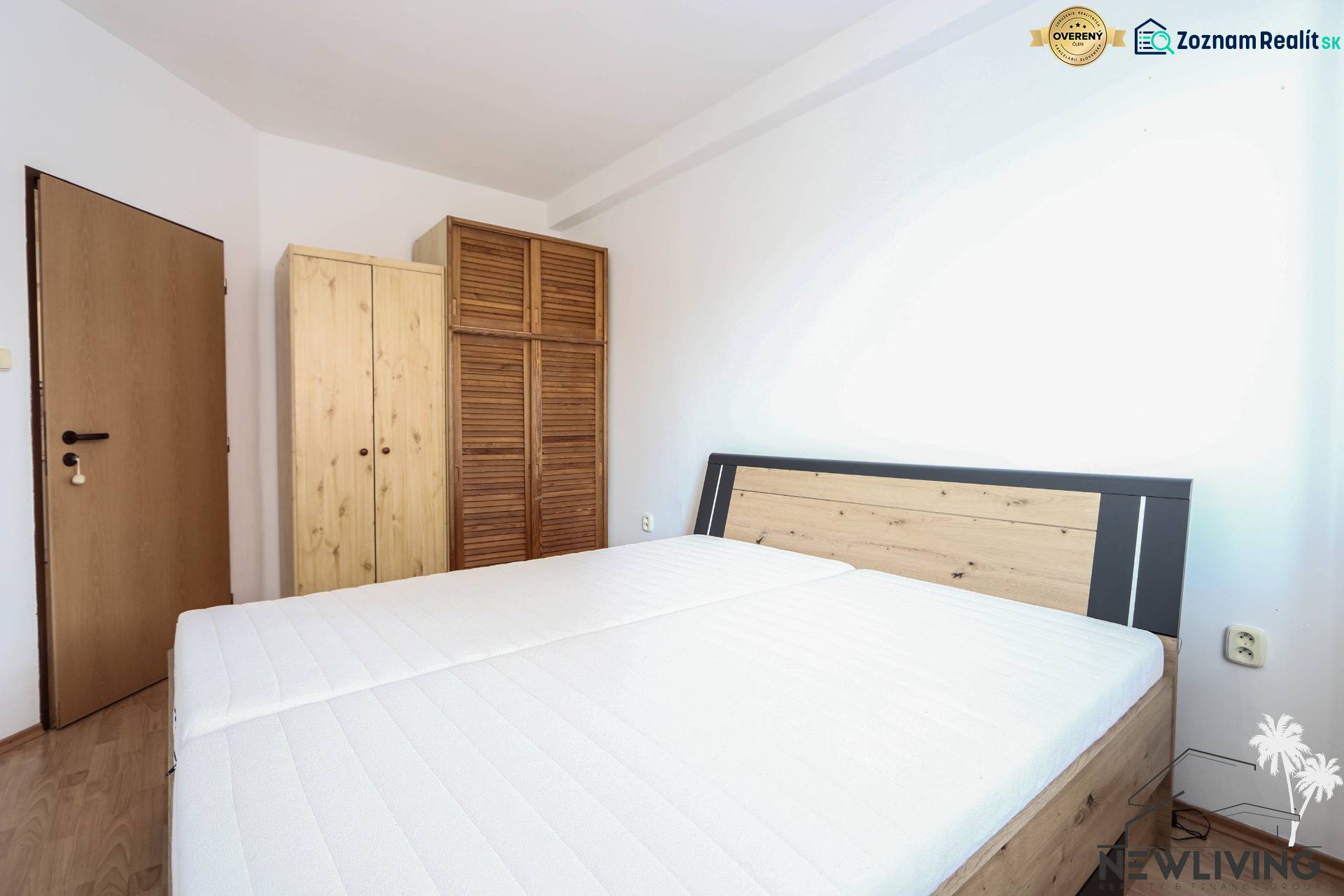 Schlafzimmer in einer 2-Zimmer-Wohnung mit Bett und Holzschränken, Boden mit Holzdekor.