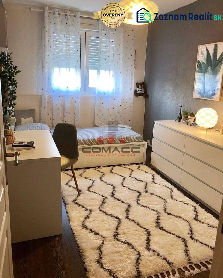 Kinderzimmer mit Schreibtisch, Teppich und Boden mit Holzdekor in einem Einfamilienhaus.