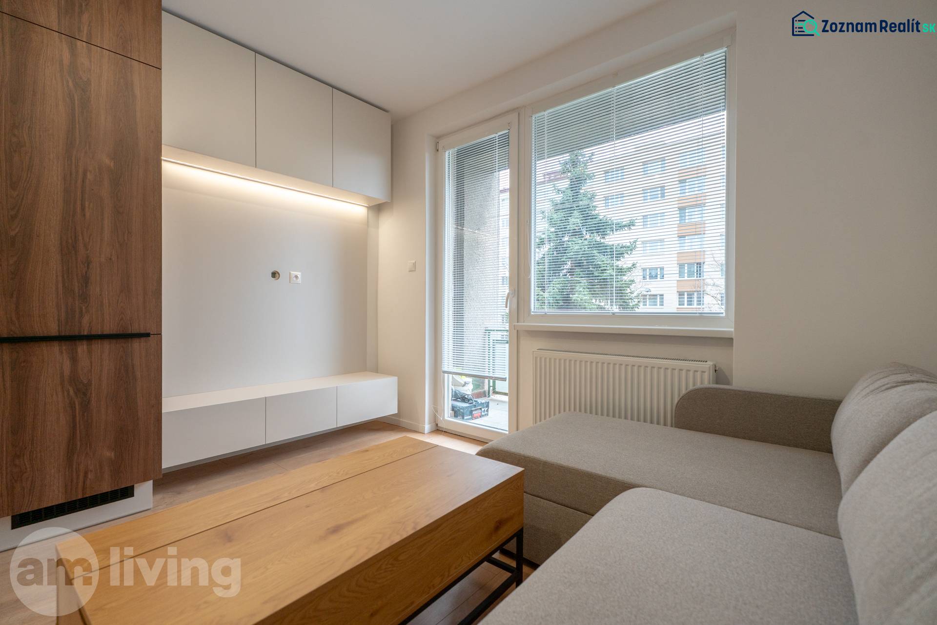 Wohnzimmer in einer 3-Zimmer-Wohnung mit Holzboden, Sofa und Möbeln.