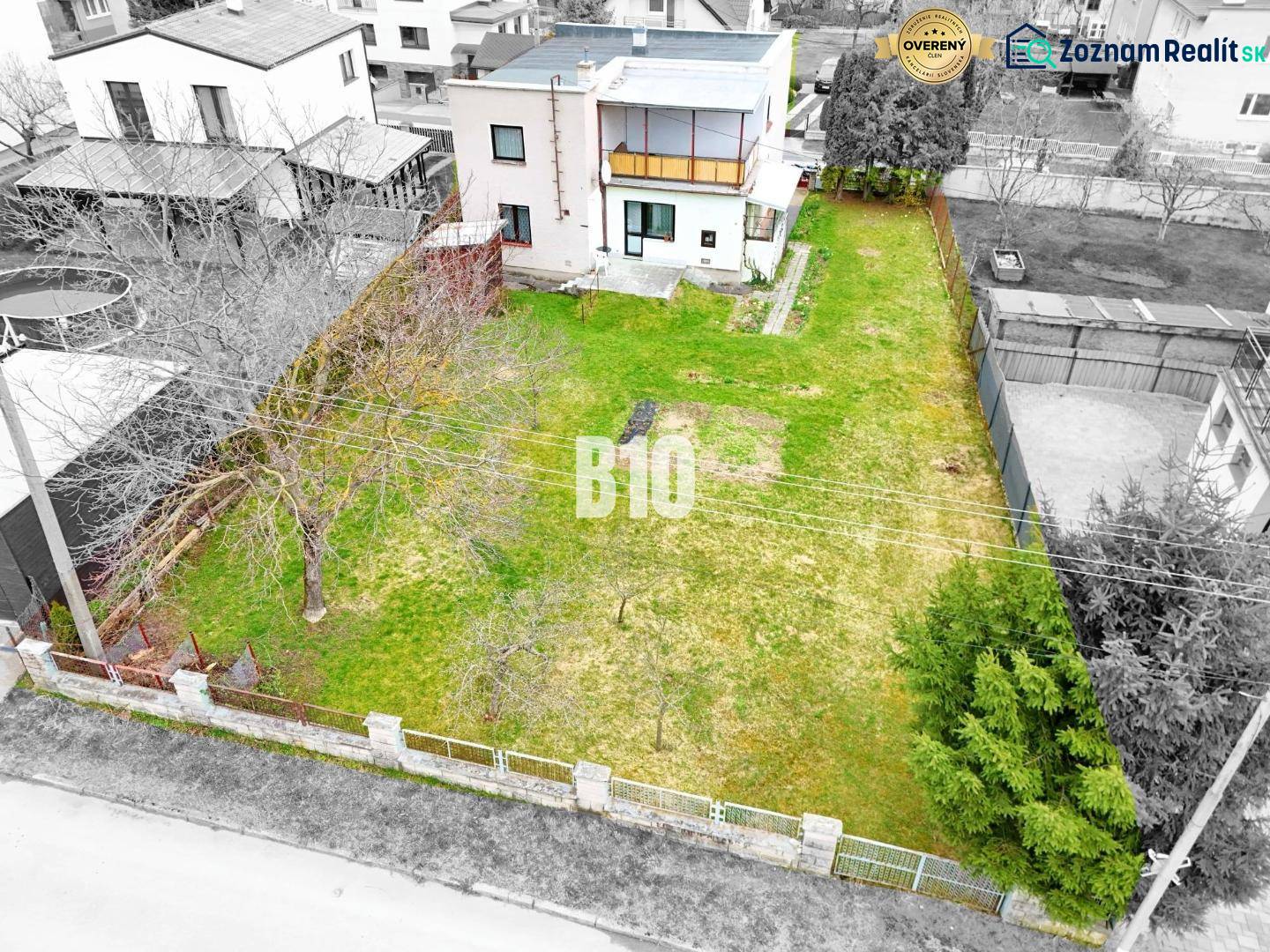 Ein Einfamilienhaus in Martin mit Garten und Bäumen, umgeben von einem Zaun für Privatsphäre.