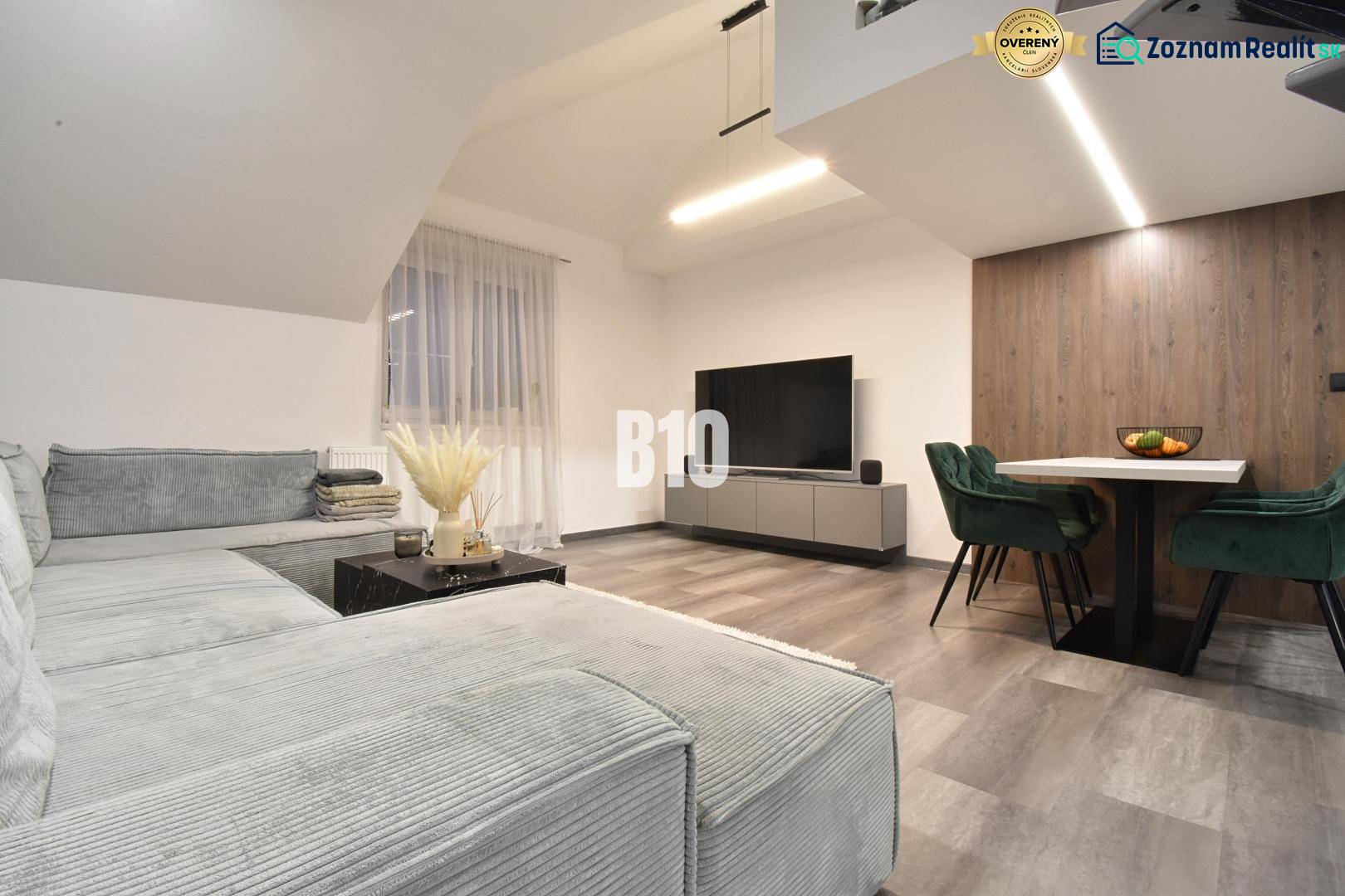 Wohnzimmer in einer 4-Zimmer-Wohnung mit Sofa, Fernseher und Holzboden.