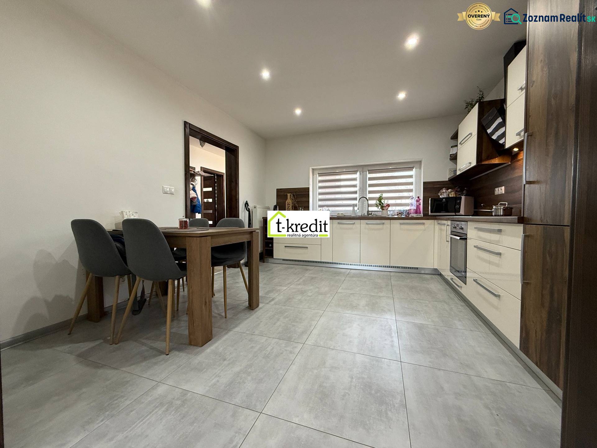 Eine Küche in hellen Farben mit eingebauten Geräten und einem Esstisch in einem Einfamilienhaus.