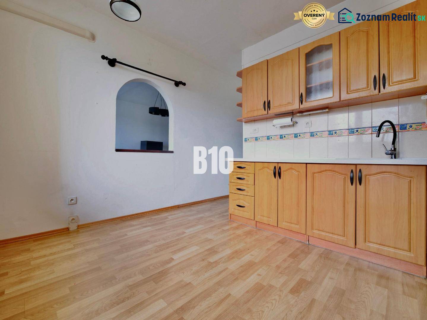 Küche in einer 3-Zimmer-Wohnung mit Holzboden und Einbauschränken.