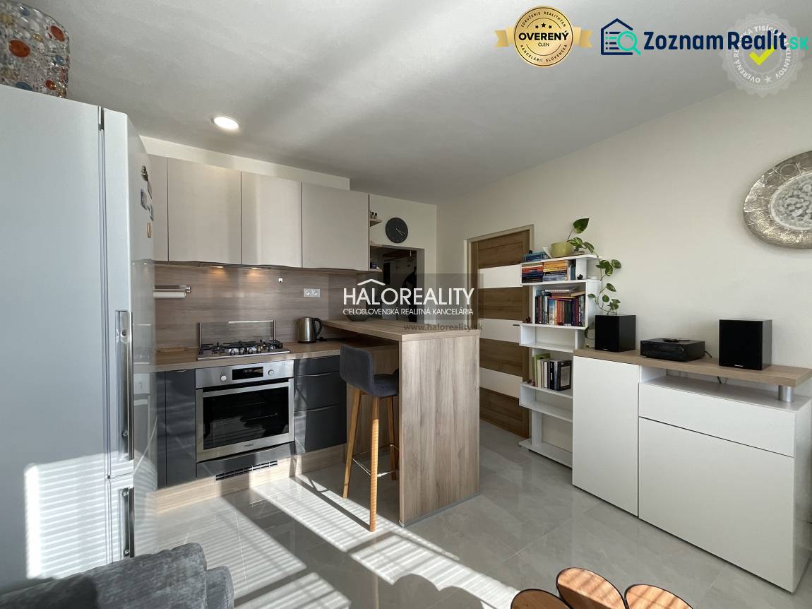 Küche in einer Einzimmerwohnung mit hellem Interieur und einer Theke zum Sitzen.