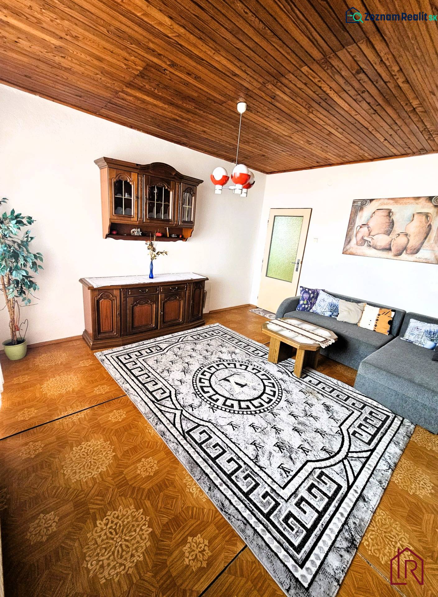 Wohnzimmer in einem Einfamilienhaus mit Holzboden und einer Sitzgarnitur.