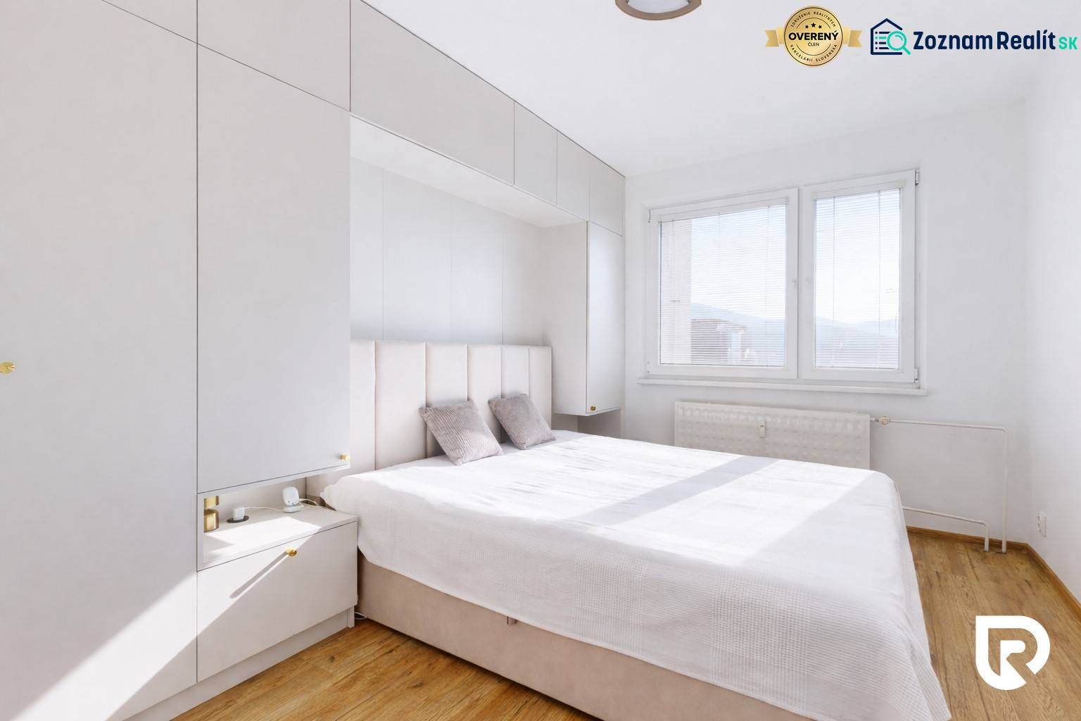 Schlafzimmer in einer 3-Zimmer-Wohnung mit Holzboden, weißen Möbeln und großem Fenster.