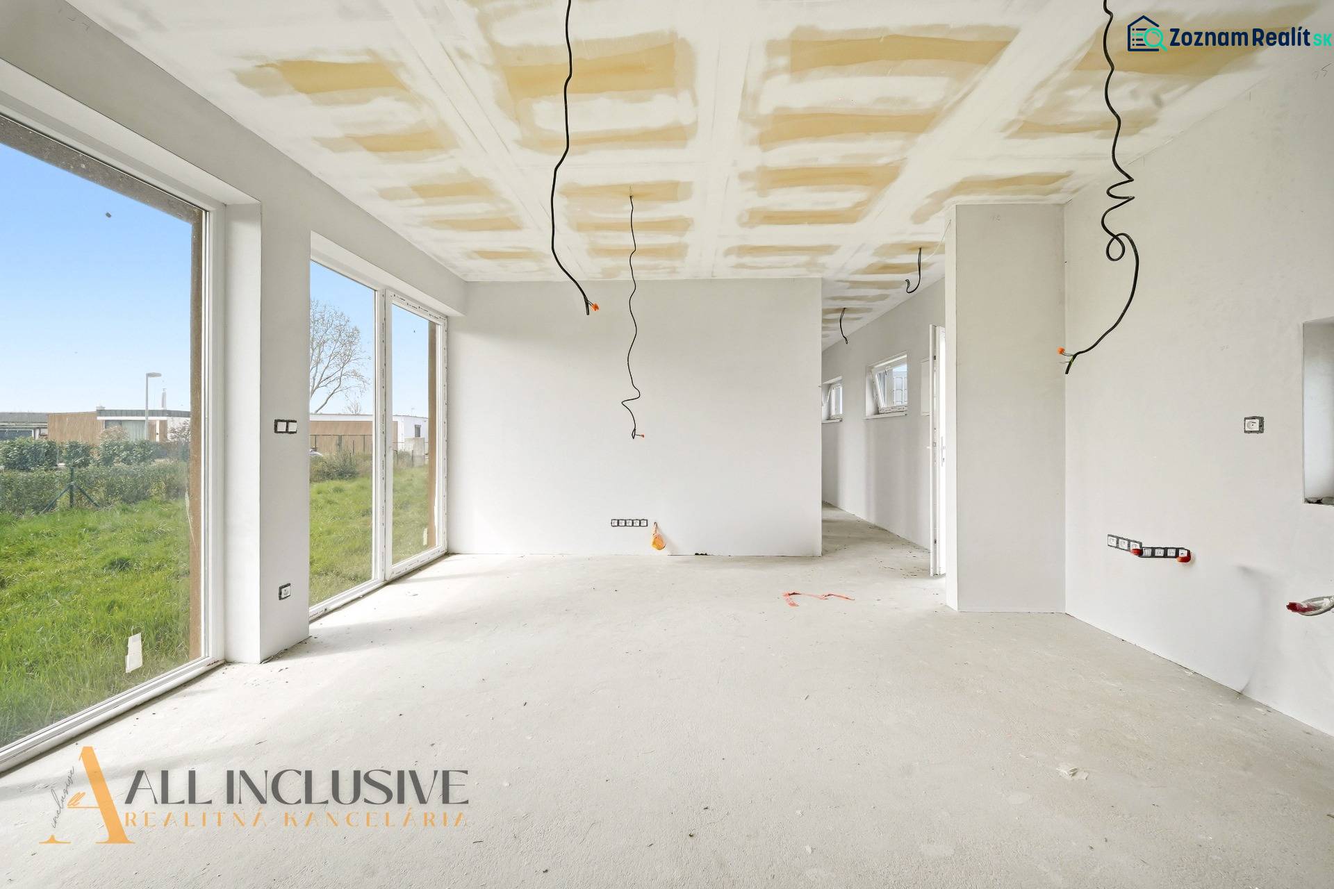 Ein geräumiges Ferienhaus mit weißen Wänden und großen Fenstern, einem Boden in Holzoptik.