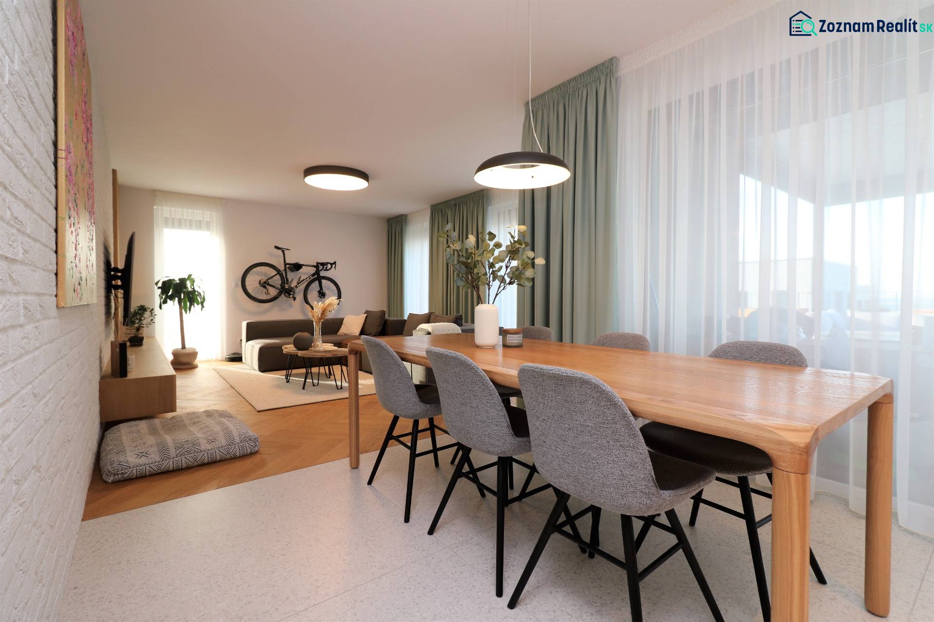 Esstisch und Wohnzimmer in einer 4-Zimmer-Wohnung mit einem Fahrrad an der Wand.