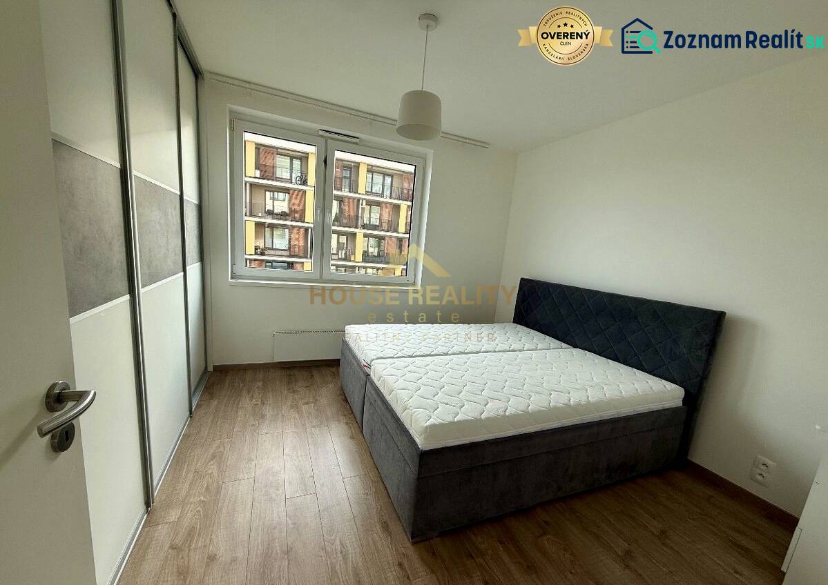 Schlafzimmer mit Einbauschrank, Doppelbett und Holzboden in einer Zweizimmerwohnung.