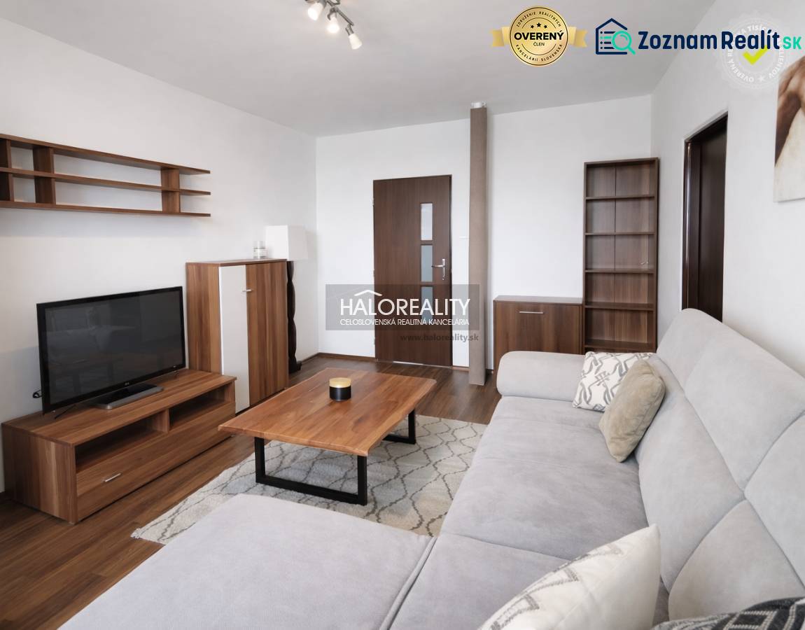 Wohnzimmer mit Holzboden, Sofa und Fernseher in einer Vierzimmerwohnung.