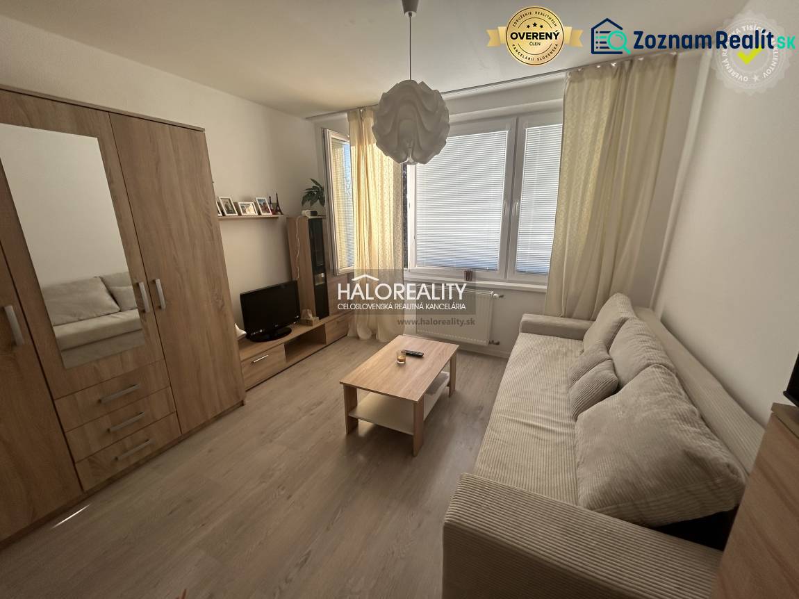 Ein Studio mit einem Boden in Holzoptik, einem Sofa und einem Schrank.