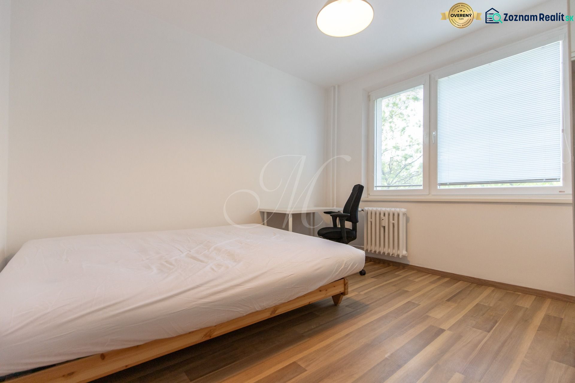 Schlafzimmer mit einem Einzelbett, einem Schreibtisch und einem Boden mit Holzdekor in einer 3-Zimmer-Wohnung.