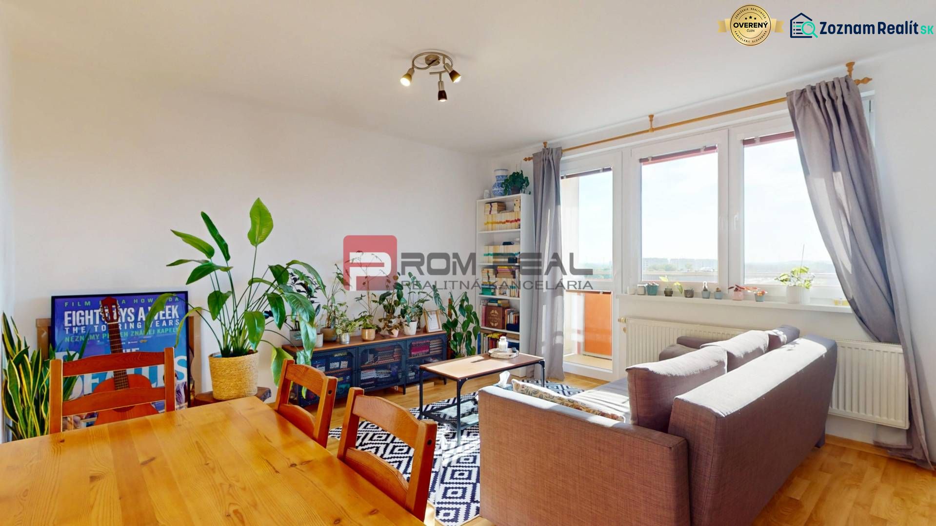 Wohnzimmer in einer 2-Zimmer-Wohnung mit üppigem Grün und sonnigem Balkon.