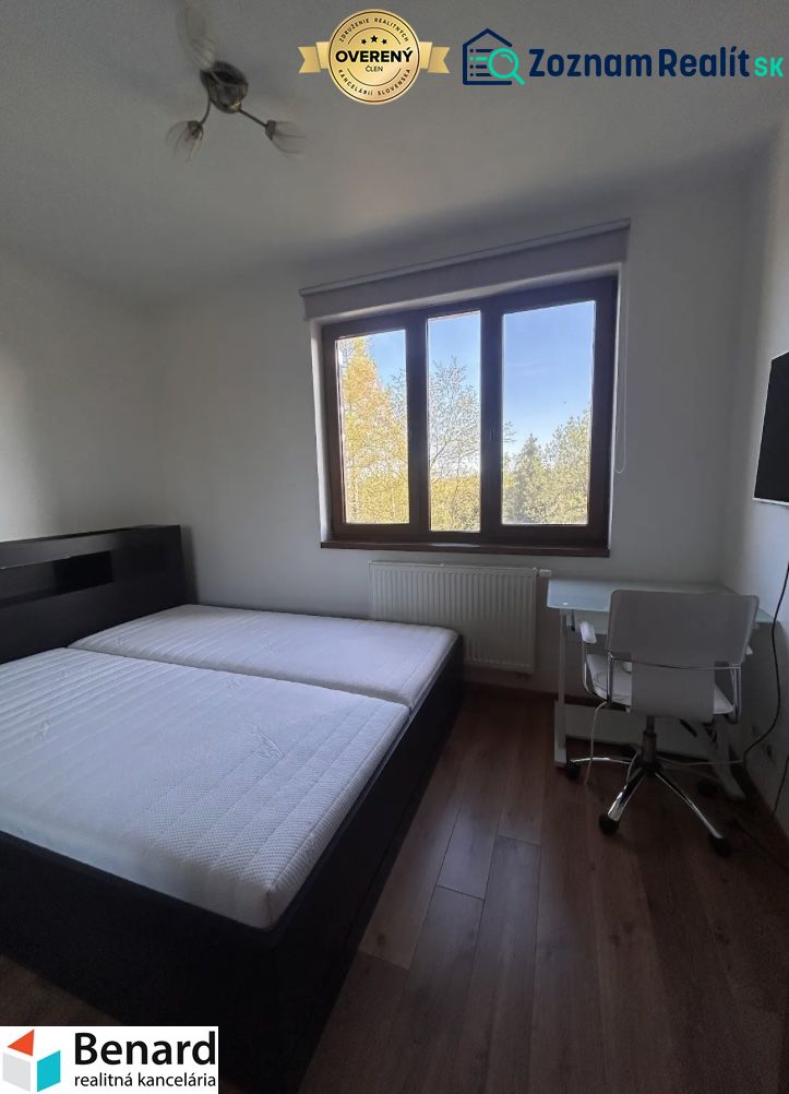 Schlafzimmer mit Bett, Tisch und Holzboden in einer 3-Zimmer-Wohnung.